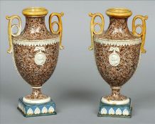 A pair of 19th century granite ware vases Each of twin handled urn form with a masked roundel to