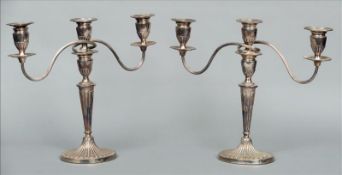 A pair of silver plated three branch candelabra Each of classical urn form above gadrooned stem