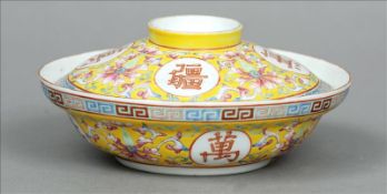 A Chinese porcelain rice bowl and cover Decorated overall with lotus strapwork on a yellow ground
