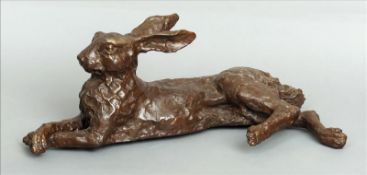 A patinated bronze model of a hare Modelled in recumbent position. 63 cms long. Overall good, some