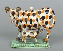 An early 19th century pearlware cow creamer Formed as a cow and calf, each with mottled