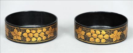 A pair of Regency painted papier mache bottle coasters Each decorated to the rim with gilt flowering