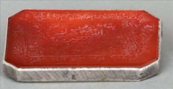 A 19th century Persian white metal mounted carnelian panel Extensively engraved with script and