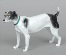 A 19th century Continental porcelain model of a dog Modelled on all fours wearing a green collar. 25