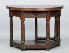 A 17th century oak credence table The hinged demi-lune top above a single frieze drawer, standing on