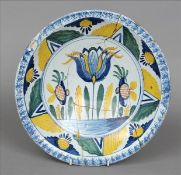 An 18th century Bristol polychrome charger Decorated to the centre with a tulip. 34 cms wide.