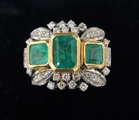 An 18 ct white gold emerald and diamond ring The three central emeralds flanked by various small