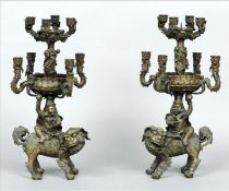 A pair of ornate Chinese bronze candelabra The four branch top tier with a central candle pricket
