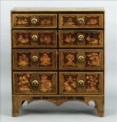 A chinoiserie lacquered chest of drawers Decorated throughout in black, gold and red with various