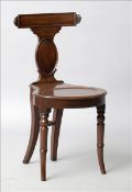 An early 19th century mahogany hall chair The carved bar back supported by an oval panelled