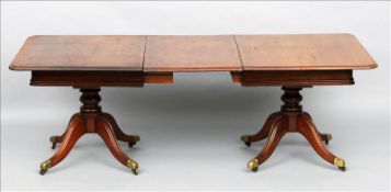 An early 19th century mahogany extending twin pillar dining table The moulded rounded rectangular