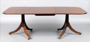 A George III style mahogany twin pillar dining table The rounded rectangular top incorporating one