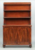 A 19th century mahogany waterfall bookcase The three shelves supported by turned uprights above twin