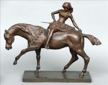 A patinated bronze model of a young girl In a dress riding a horse side saddle, standing on a plinth