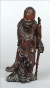 An 18th/19th century finely carved wooden figure of a sage Holding a bat in his hand. 22 cms high.