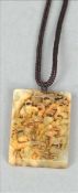 A Chinese carved white and russet jade pendant Of rectangular form, decorated with animals in a