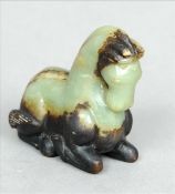 A Chinese carved green and black jade group Modelled as a recumbent horse. 6 cms high. Generally