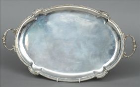 A Greek silver tray Of lobed oval form with twin scroll cast handles, stamped 925. 50 cms wide. Some