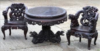 A pair of Oriental carved open armchairs Each ornately carved with dragons and various mythical