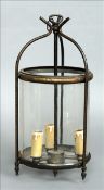 A late 19th/early 20th century brass framed three light hall lantern Of glazed cylindrical form.