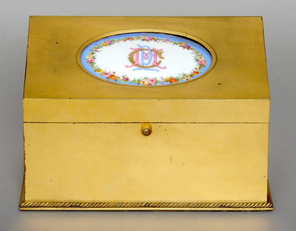 A 19th century gilt brass stationery box The hinged sloping lid inset with a porcelain plaque