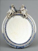 A 19th century Sitzendorf porcelain strutt mirror The top mounted with cherubs tying a floral