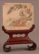 A small Oriental carved ivory panel Depicting a bearded gentleman playing a musical instrument,