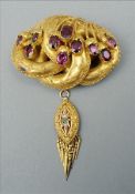A 19th century garnet set unmarked yellow metal brooch The entwined main body issuing garnet