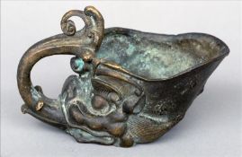 A Chinese bronze libation cup Modelled as a mythical beast mask, the tongue forming the handle,