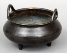 A Chinese patinated bronze censor The squat bulbous body with flared neck rim and twin loop handles,