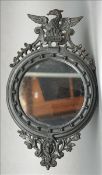 A 19th century cast iron wall mirror The circular plate surmounted with the figure of a phoenix,