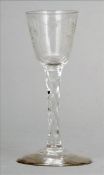 A 19th century wine glass The etched bowl above a faceted stem, standing on a domed spreading