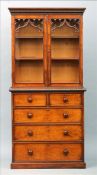 A Victorian mahogany bookcase on chest The lappet carved cornice above twin glazed doors with arched