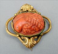 An 18th/19th century unmarked yellow metal framed coral brooch/pendant The scrolling pierced frame