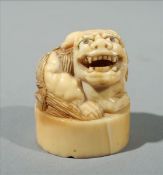 A carved ivory seal netsuke Carved with the figure of a shi-shi 3.5 cms high. Generally in good