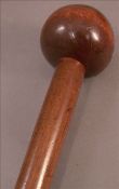 An African carved wood knobkerrie Of typical form. 87.5 cms long. Generally in good condition,