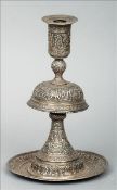 A 19th century white metal table candlestick, possibly Persian, probably silver Extensively embossed