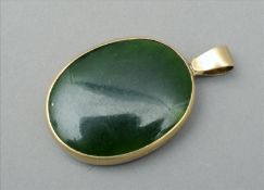 An unmarked silver gilt and enamel locket The oval body inset with a jade green enamel panel below a