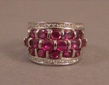 An 18 ct white gold ruby and diamond ring Set with three bands of rubies bordered by two bands of