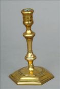 An 18th century brass chamberstick Of typical form with knopped stem, standing on a hexagonal