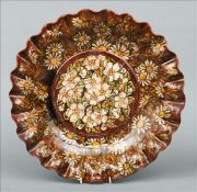 A Linthorpe pottery charger The centre floral moulded, the rim crimped, impress mark to base,