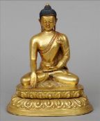 A Sino-Tibetan gilt bronze Buddha With patinated hair and seated in the lotus position on a lappet