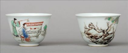 A pair of Chinese porcelain tea bowls Each decorated with figures in a continuous landscape, blue