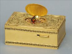 A gilt metal bird automaton music box The hinged lid enclosing a feather bird, the top with cast