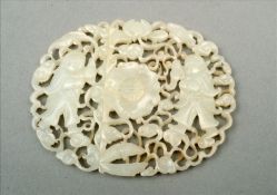 A Chinese mutton fat jade buckle Of pierced and carved form, decorated with figures amongst scroll