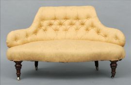 A small Victorian button backed settee The low back above an overstuffed seat, standing on turned