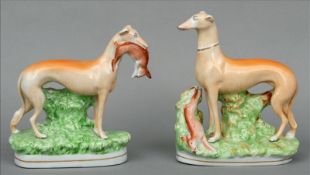 A matched pair of 19th century Staffordshire figures of greyhounds One modelled holding a hare in
