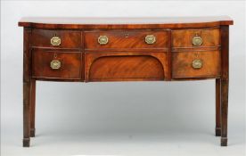 A George III mahogany sideboard The ebony line inlaid shaped rectangular top above an arrangement of