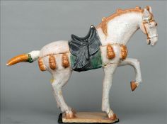 A Chinese pottery Tang style horse Typically modelled. 44 cms high. Generally in good condition,