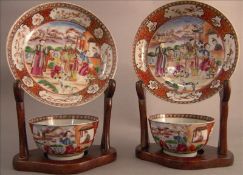 A pair of Chinese porcelain tea bowls and saucers Each decorated with figures in a garden within a